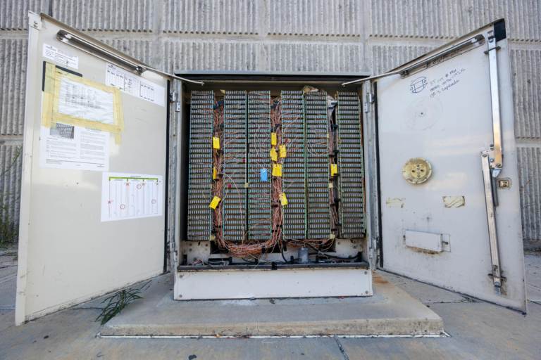 Open outdoor telephone junction box showing internal wiring and connectors.